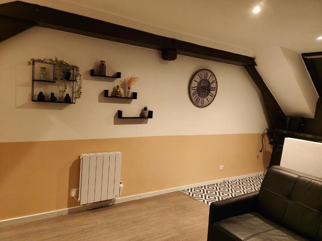 ein Wohnzimmer mit einem Sofa und einer Uhr an der Wand in der Unterkunft Les Lofts De Provins: Apt 8 in Provins