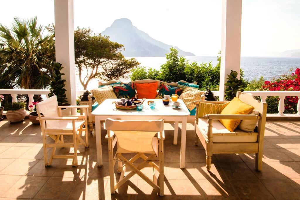 einen Tisch und Stühle auf einer Terrasse mit Meerblick in der Unterkunft Casa Azul villa for rent in Kalymnos