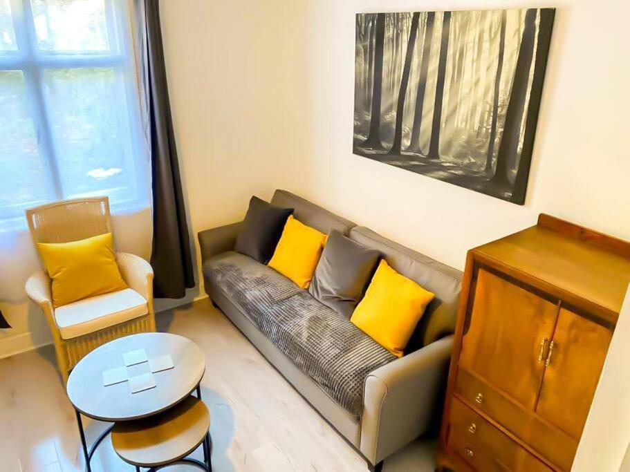 uma sala de estar com um sofá com almofadas amarelas em Gravesend 2 Bedroom Spacious Stylish Apartment - Sleeps upto 6 - 2 Min Walk to Station em Kent