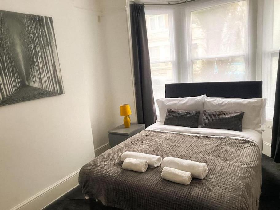 een slaapkamer met een bed met twee handdoeken erop bij Gravesend 2 Bedroom Spacious Stylish Apartment - Sleeps upto 6 - 2 Min Walk to Station in Kent