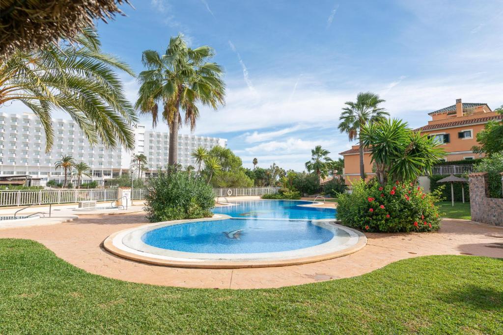 uma piscina num parque com palmeiras em Es Mirador - Cales de Mallorca em Calas de Mallorca