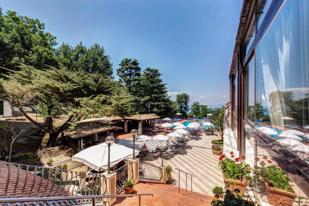 balkon budynku ze stołami i parasolami w obiekcie Villa Romita w mieście SantʼAgata sui Due Golfi