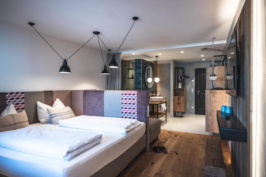 Letto o letti in una camera di Sport & Wellness Hotel Das Falkenstein - Natural Swimming Lake - Matrix GYM - Summercard inklusive - Authentic experience - Flying wellness with Pool