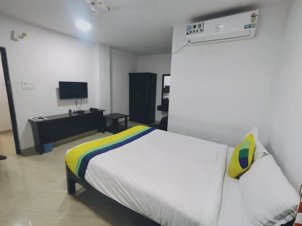 a bedroom with a white bed and a tv at HOTEL AMIGOS in Hyderabad