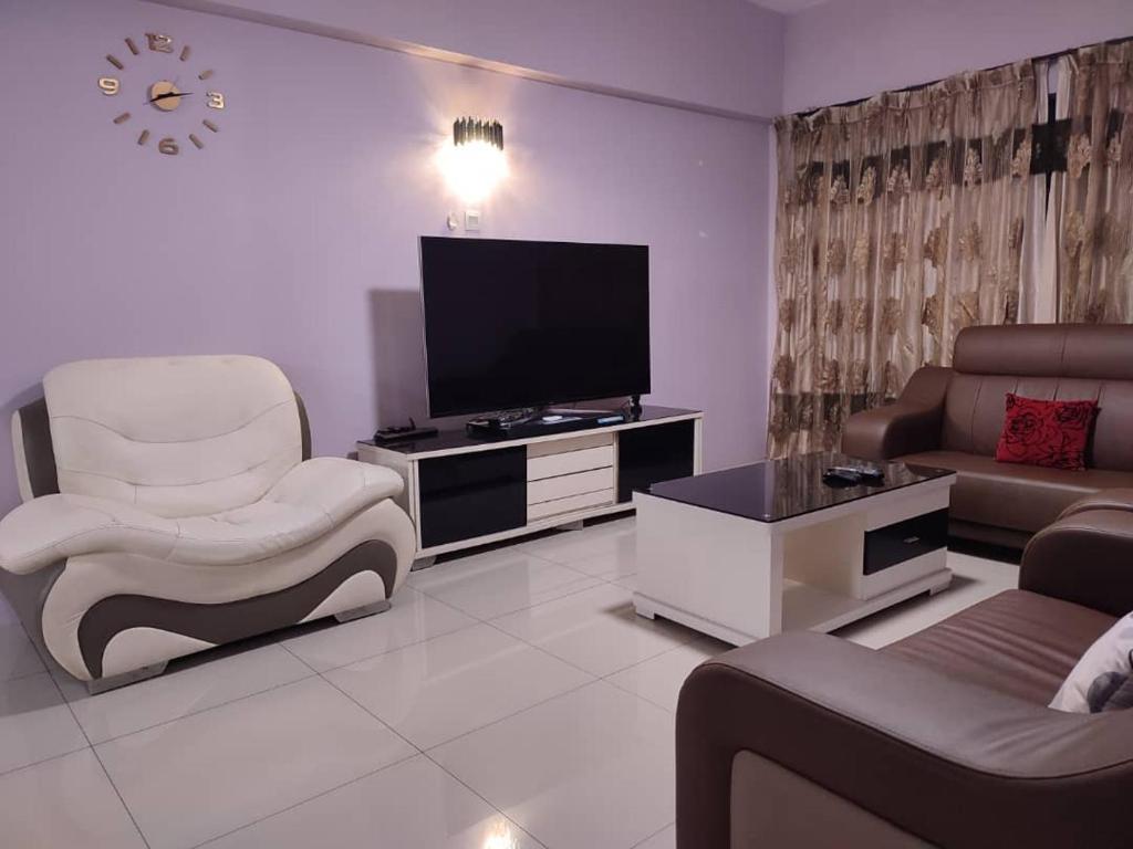 a living room with a couch and a television at Daxxlence Swimming Pool Homestay Kinta RiverFront in Ipoh