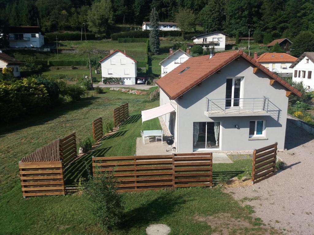 een wit huis met een houten hek in een veld bij Gîte Saulxures-sur-Moselotte, 4 pièces, 6 personnes - FR-1-589-242 in Saulxures-sur-Moselotte