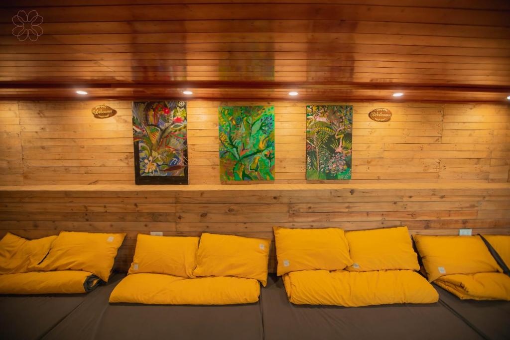 a room with yellow pillows and paintings on the wall at Đồi Gió Retreat in Hanoi