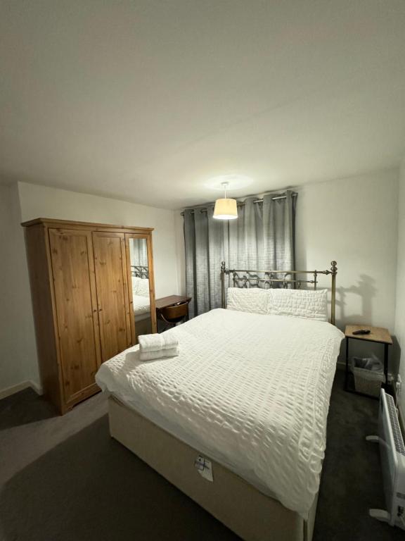 a bedroom with a large bed with white sheets at Master room in Bristol