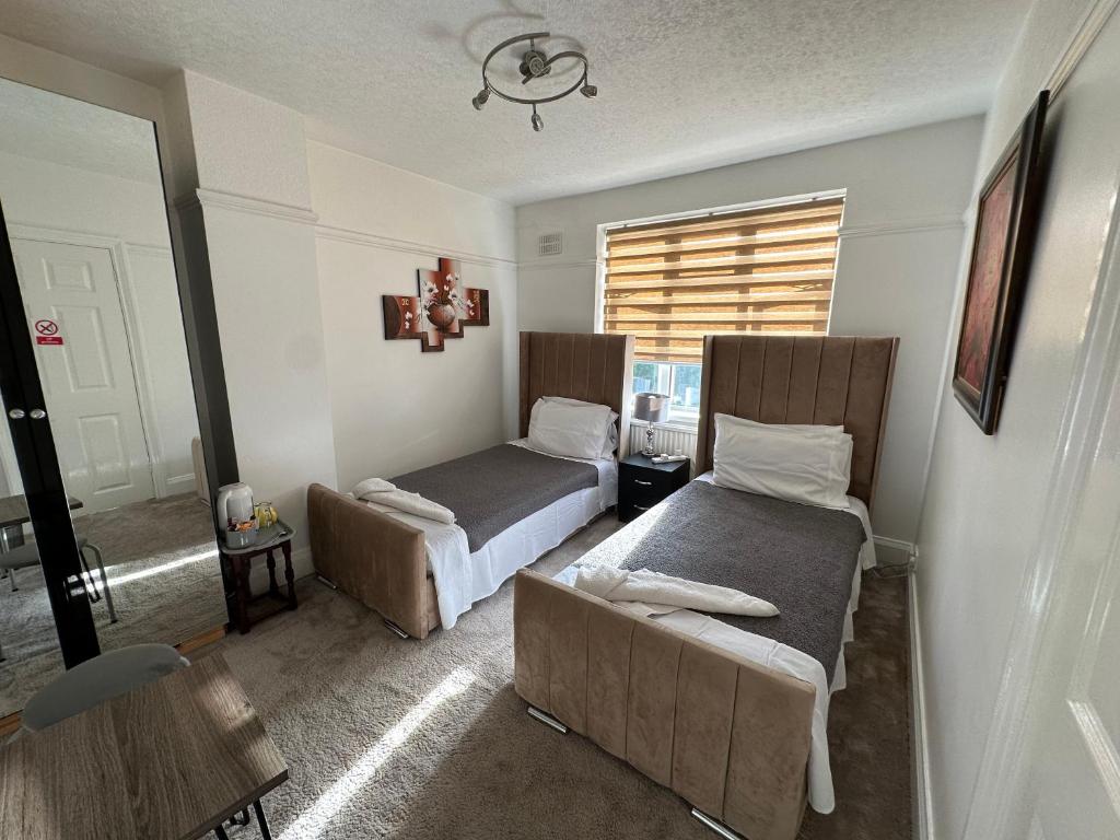 a bedroom with two beds and a couch and a window at Sheri's Home away in Hither Green