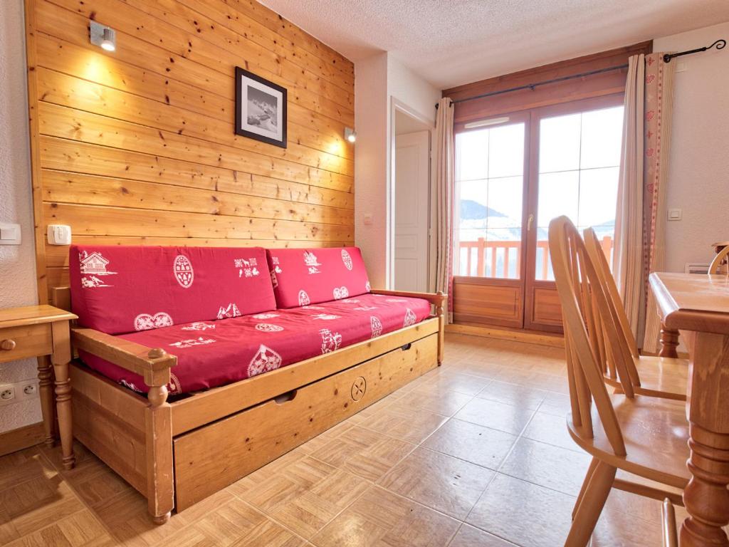 - un canapé dans une chambre dotée d'un mur en bois dans l'établissement Appartement cosy avec piscine, au pied des pistes, parfait pour 4 personnes - FR-1-505-112, à Flumet