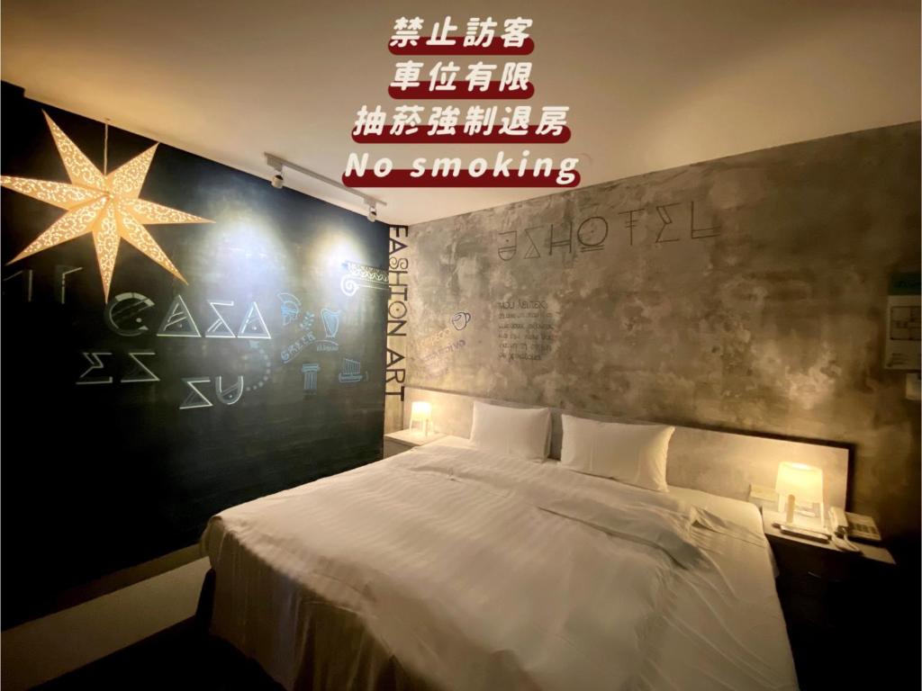 a bedroom with a bed with a no smoking sign at JS Hotel-Gallery Hotel in Zhongli