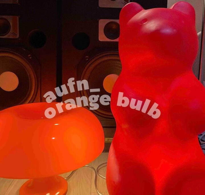 a red stuffed teddy bear sitting next to a balloon at Aufn Orange Bulb in Seoul