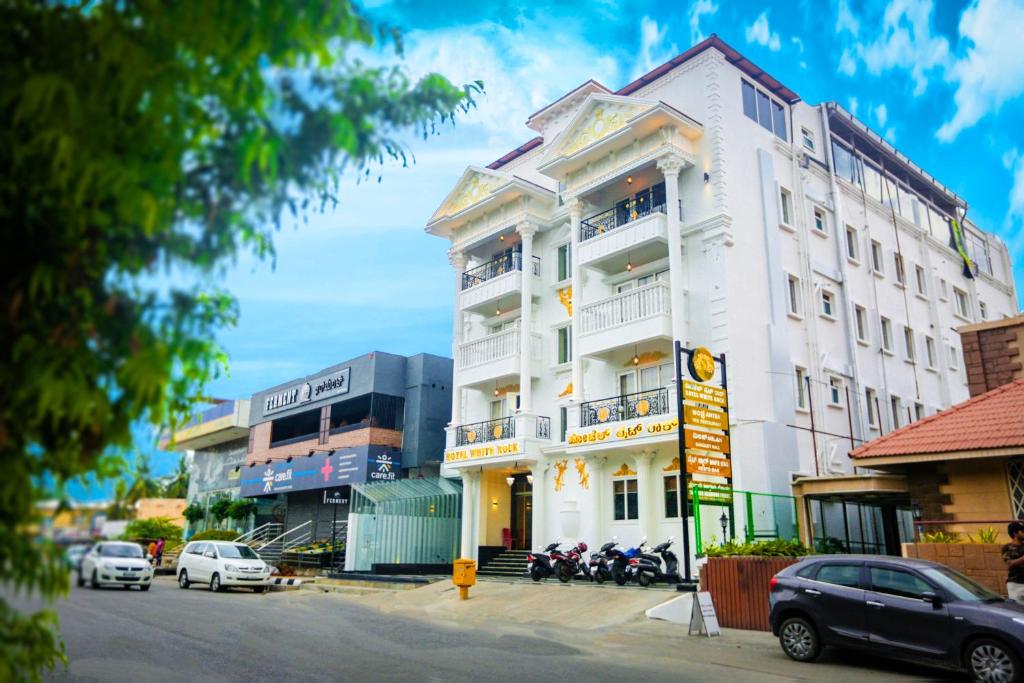 um edifício branco com motos estacionadas em frente em Hotel White Rock em Bangalore