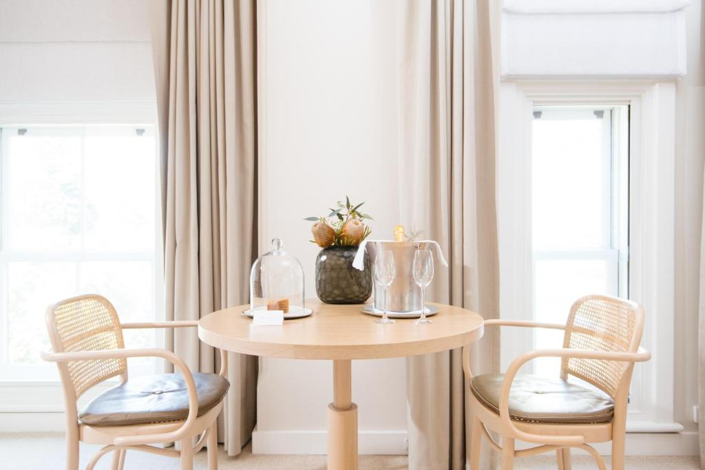 a table with two chairs and a vase on it at COMO The Treasury in Perth