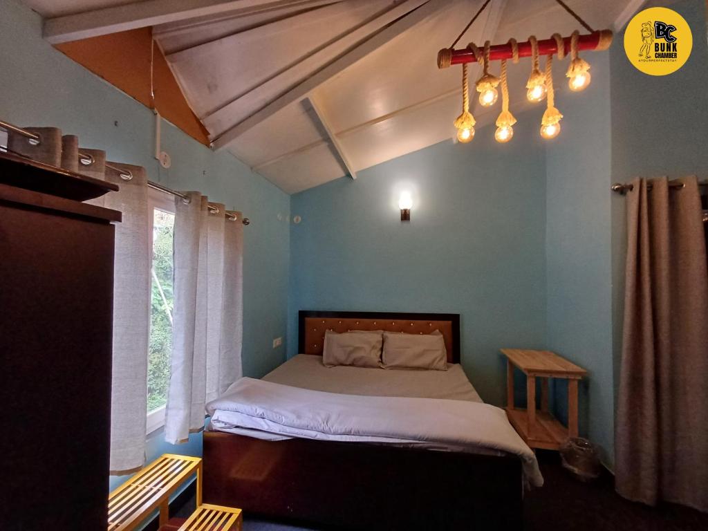 een slaapkamer met een bed in een blauwe kamer bij BUNK CHAMBER in Mukteswar