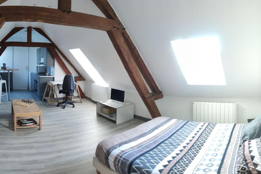 a bedroom with a bed and a desk with a computer at Appartement de Charme in Lacroix-Saint-Ouen