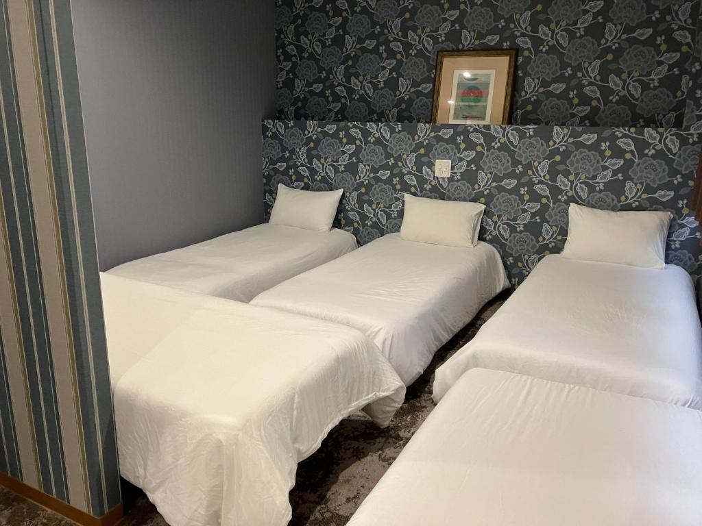 - 3 lits dans une chambre avec des draps blancs dans l'établissement AO Dazaifu / Vacation STAY 61732, à Chikushino