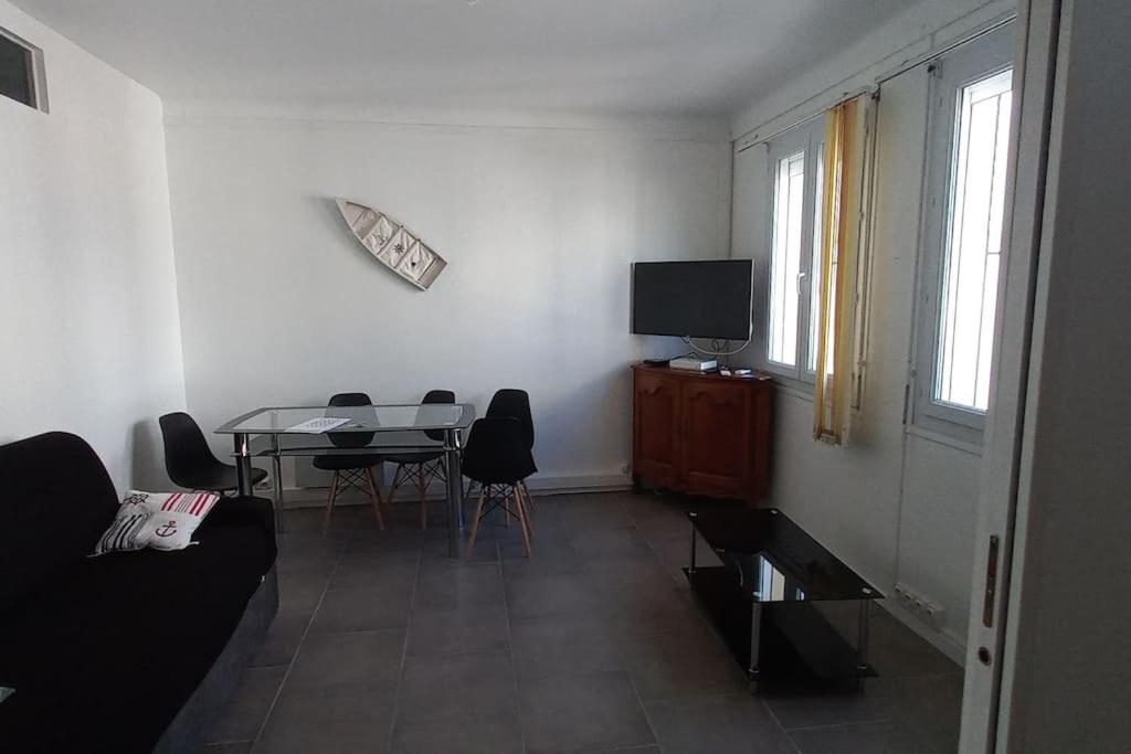 un salon avec une table et une télévision dans l'établissement Barcarès village - RdC de maison indép. 2/6 p, au Barcarès