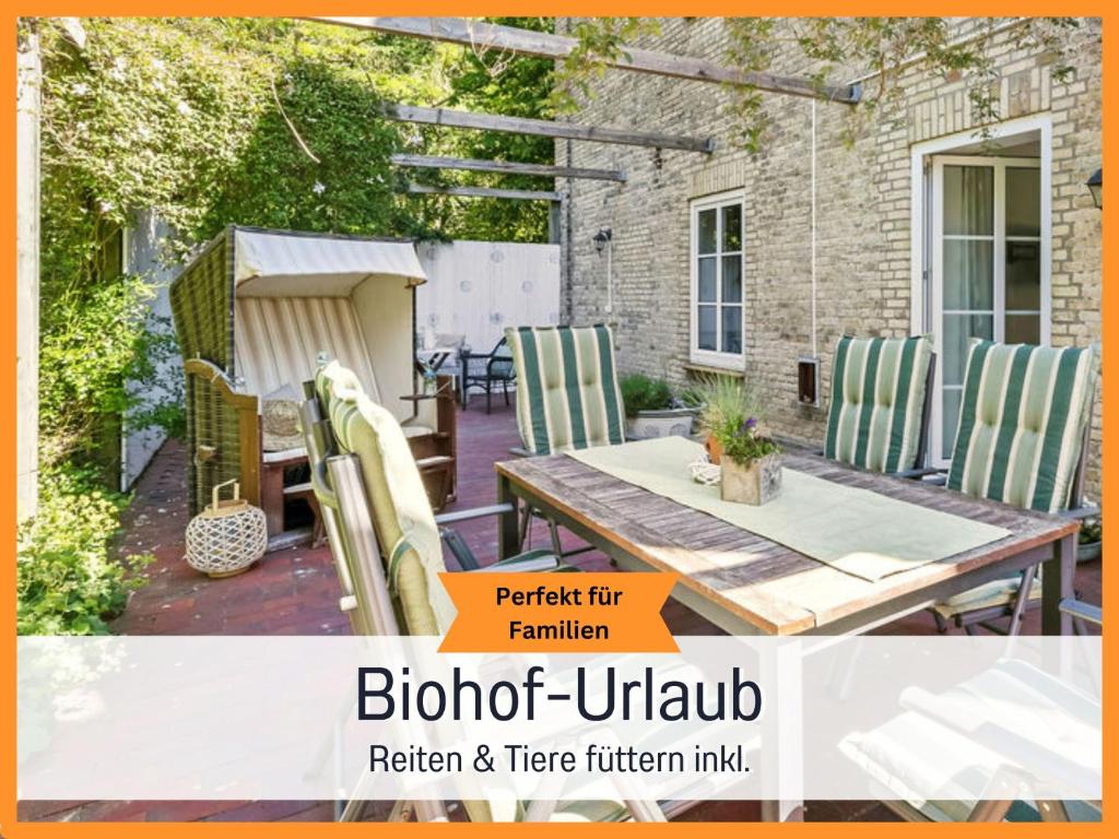 eine Terrasse mit einem Holztisch und Stühlen in der Unterkunft Bio Ferienhof Wichtelweide - Fewo Calendula in Fehmarn
