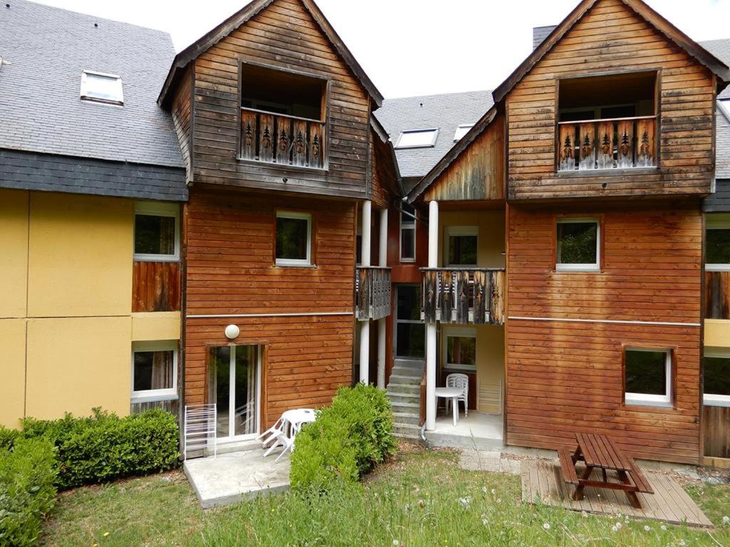une maison en bois avec une terrasse et un banc dans l'établissement Appartement Cauterets. 4/6 pers, à Cauterets