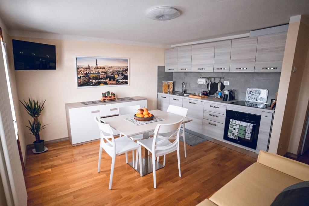 una cocina con mesa blanca y sillas. en Appartamento - Borgo55 - Centro Paese, en Bosco Chiesanuova
