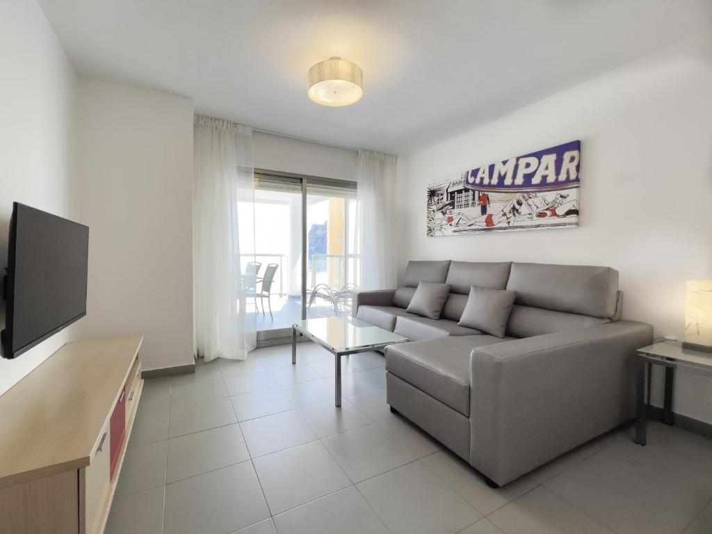 a living room with a couch and a tv at Apartamentos Hipocampos Calpe Rent Apart in Calpe