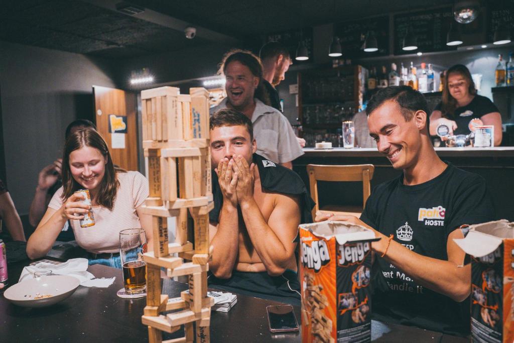 Eine Gruppe von Menschen, die an einem Tisch sitzen und Essen essen. in der Unterkunft Patio Hostel Dorms in Bratislava