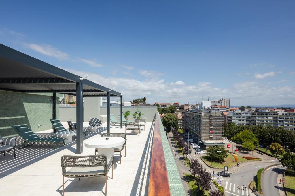 - un balcon avec des chaises et une table dans un bâtiment dans l'établissement Acta The Clover, à Porto