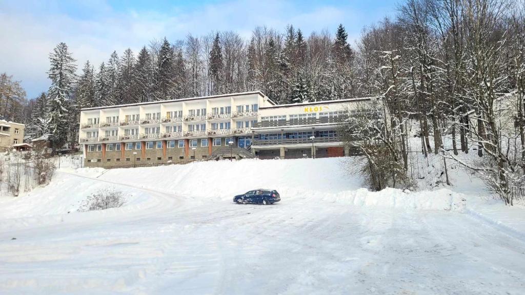 Ośrodek Wczasowy Kłos في فيسلا: وجود سيارة في الثلج امام مبنى
