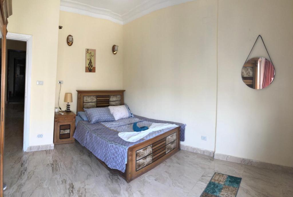 een slaapkamer met een bed en een spiegel aan de muur bij Sweet Home Downtown Cairo in Caïro