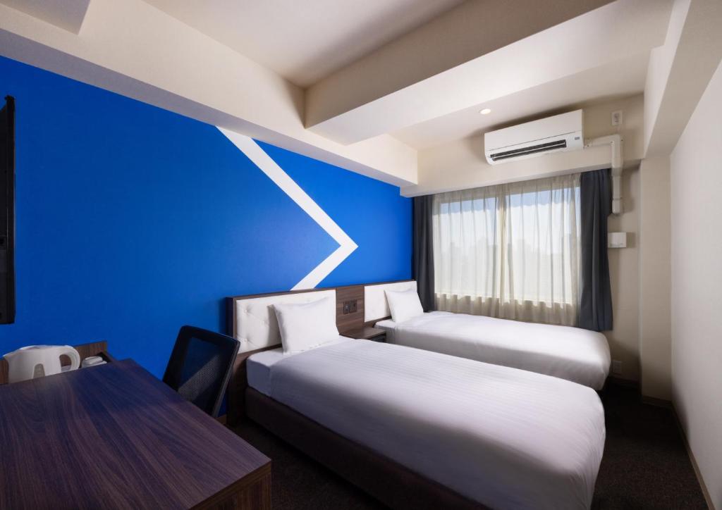 Postel nebo postele na pokoji v ubytování ibis Budget Osaka Umeda