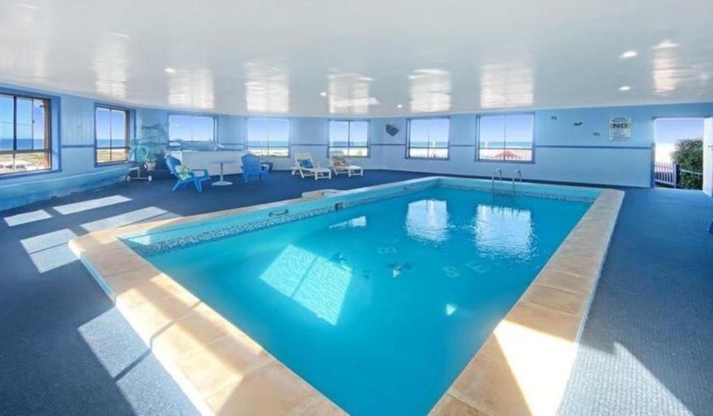 a large swimming pool with blue water in a room at Blue Seas Holiday Villas in Scamander