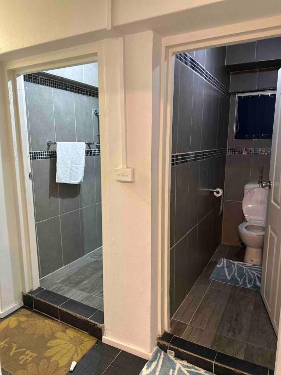 La salle de bains est pourvue d'une douche et de toilettes. dans l'établissement Home Away Comfort stay, à Suva