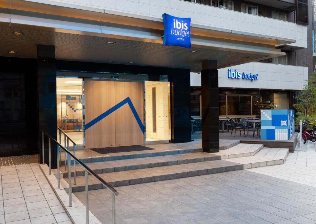 a store with a blue sign on the front of a building at ibis Budget Osaka Umeda in Osaka