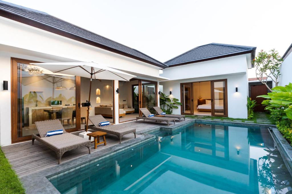 a villa with a swimming pool and a house at J4 Villas Sanur in Sanur