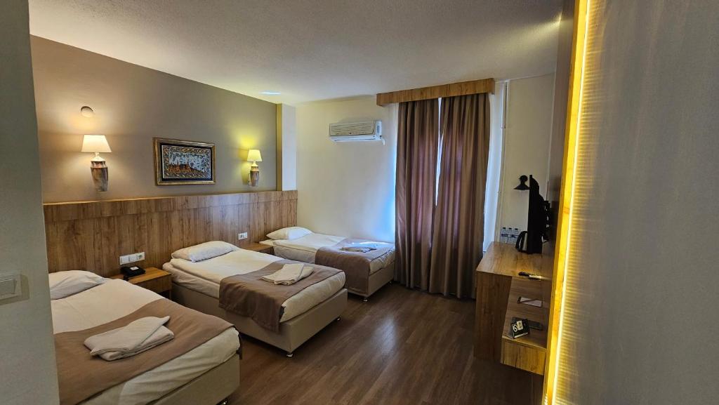 a hotel room with two beds and a window at Cappadocia Mihran Sultan in Avanos