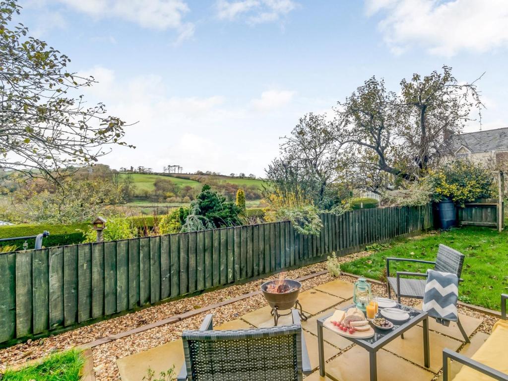 a patio with a table and chairs and a fence at 3 Bed in Barnstaple 77506 in Bishops Tawton