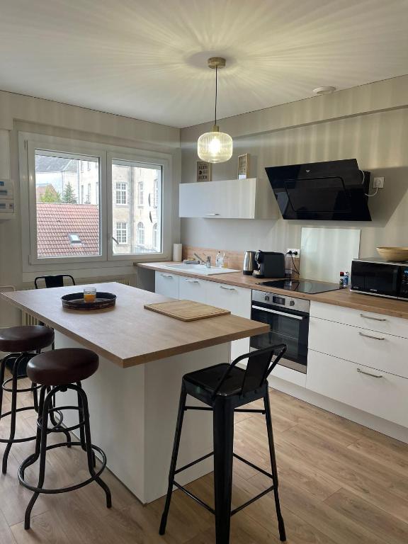 une cuisine avec une table et deux tabourets de bar dans l'établissement 2 chambres • Centre-historique, à Bourges