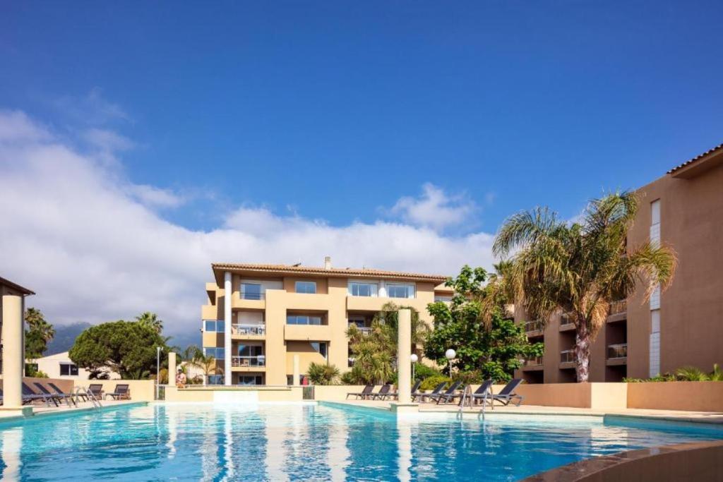 une piscine devant un immeuble dans l'établissement Résidence Marina Bianca, à Santa-Lucia-di-Moriani