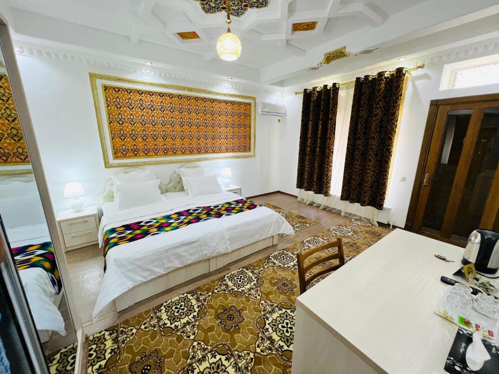 a bedroom with a large bed and a table at Hotel Lola in Bukhara