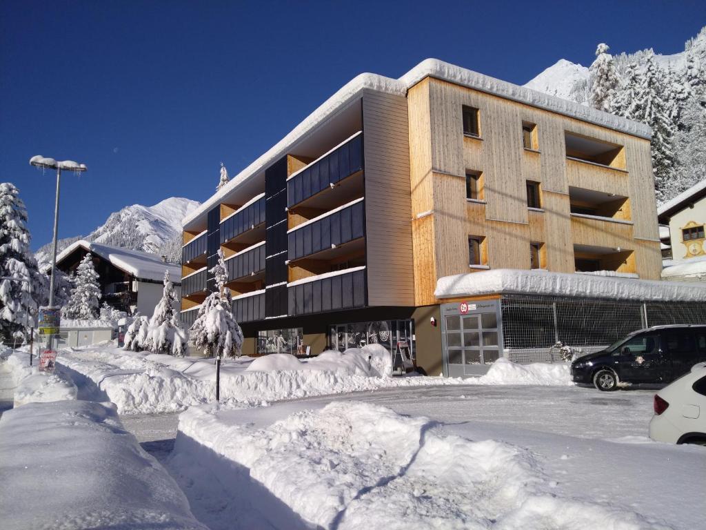 een gebouw met veel sneeuw ervoor bij Zapfig Living Arlberg in Wald am Arlberg