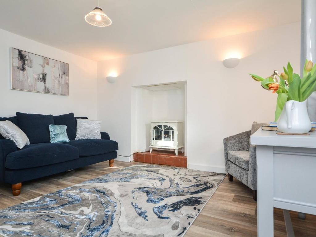 a living room with a blue couch and a chair at 3 Bed in Bude 83223 in Marhamchurch