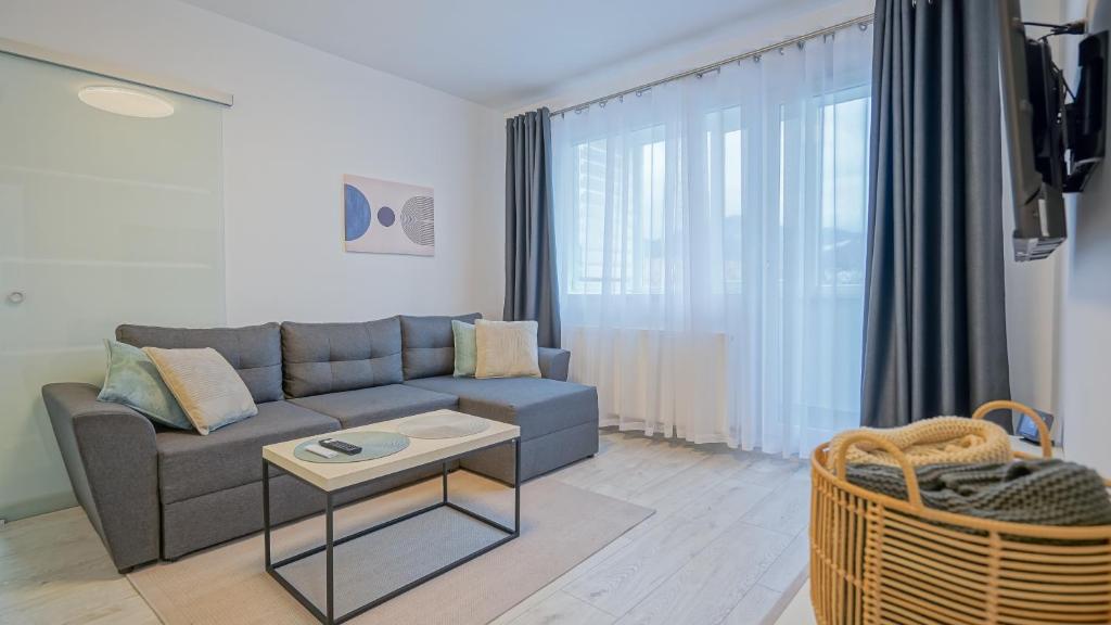 a living room with a couch and a table at Mountain Hideaway Apartment in Braşov