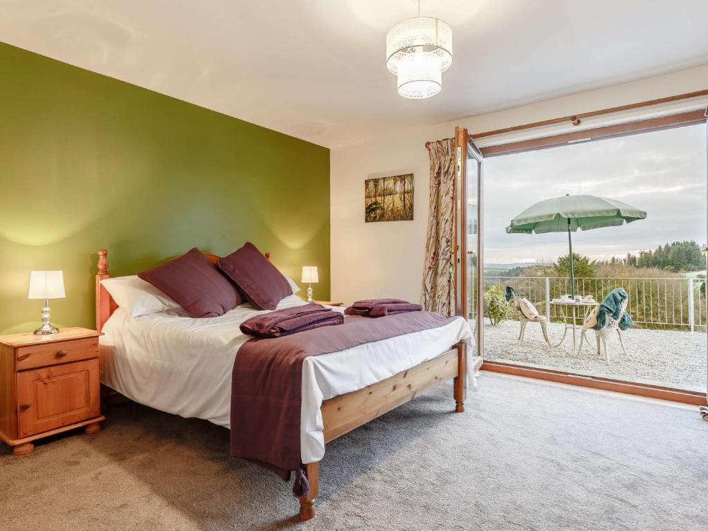 a bedroom with a bed and a balcony with an umbrella at 1 Bed in Liskeard 85888 in Saint Neot