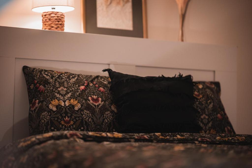 a black pillow sitting on a bed with a lamp at Viljandi Jahiloss in Viljandi