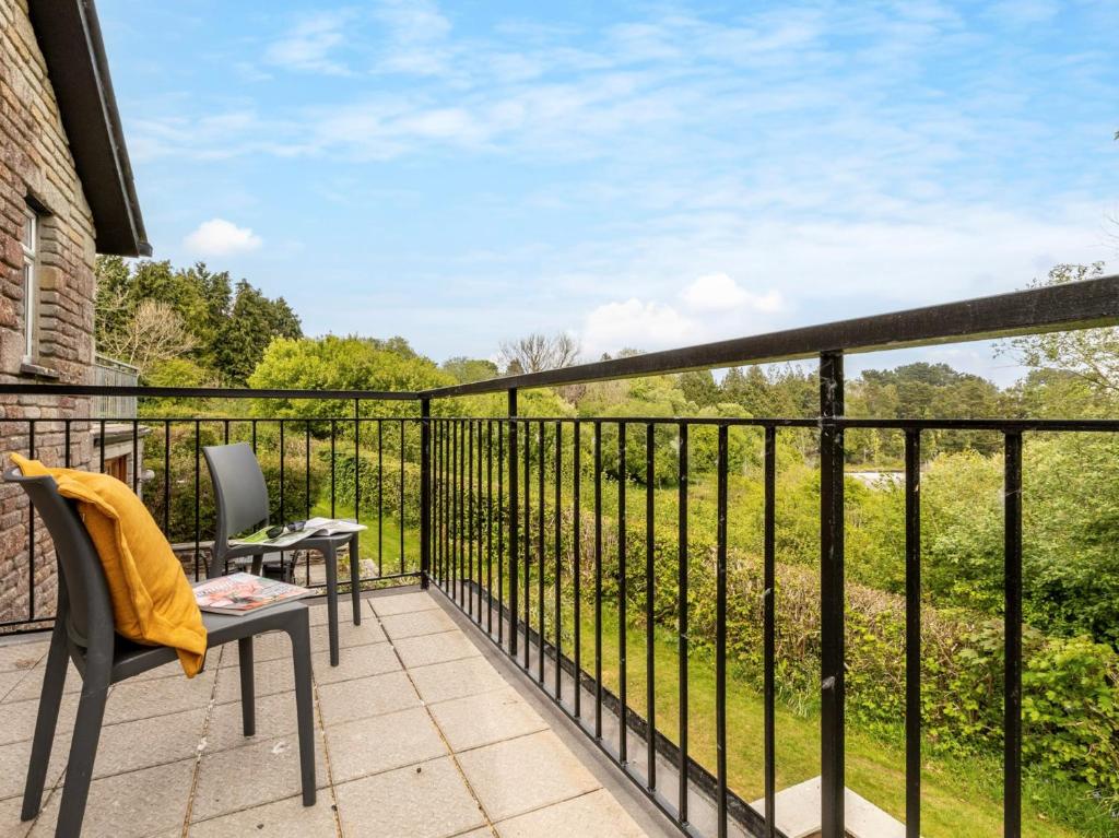 balcón con barandilla negra, mesa y sillas en 2 Bed in St. Mellion 87706, en St Mellion