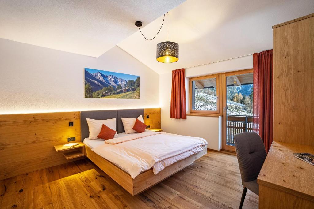 1 dormitorio con cama y ventana en App Hubertus - Wasserfallspitz, en Sand in Taufers