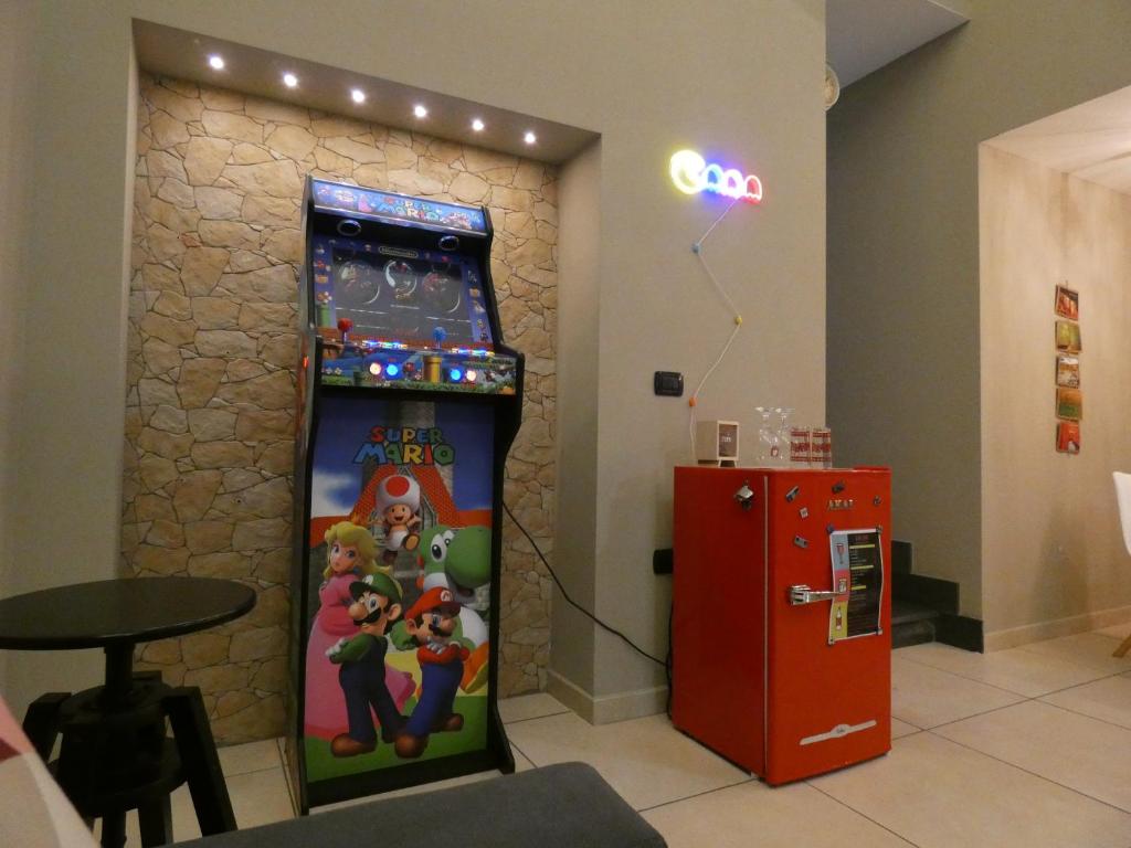 una macchina per videogiochi accanto a un distributore automatico rosso di Senza Pressa b&b a Portici