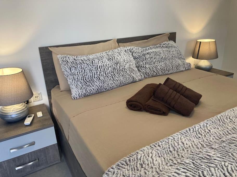 a bed with two pillows and two lamps on it at Elegant Maisonette in Malta by AssetFlow PRO in Marsaskala