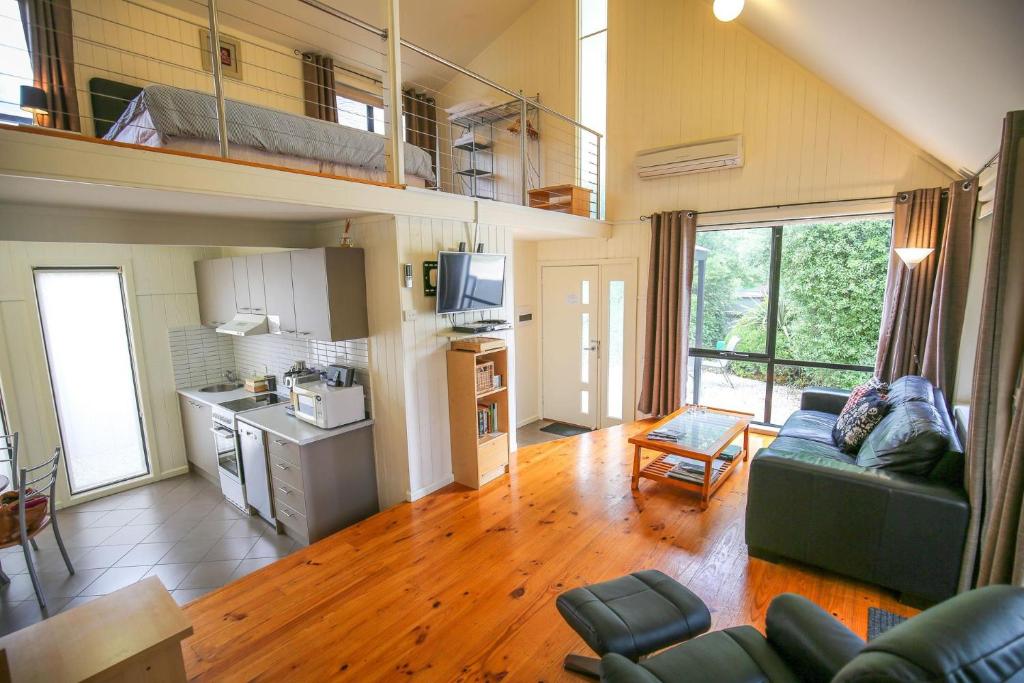 ein Wohnzimmer mit einem Sofa und einer Küche in der Unterkunft Allambie Cottages - Villa 1 in Bright